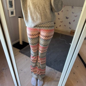 Mönstrade bootcut byxor i pastell - Säljer ett par färgglada bootcut byxor med zickzack-mönster i flera olika färger. Byxorna är högmidjade och har ett mjukt material. Nypris 299kr. De är i storlek 170 men det passar XS/S💞🛍️