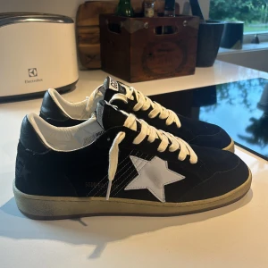 Golden Goose Ballstar sneakers svart/vit - Säljer ett par Golden Goose Ballstar sneakers i svart mocka. Skorna är näst intill nyskick. Storlek 43. Jag säljer dom eftersom de inte passade på mig. Pris kan diskuteras