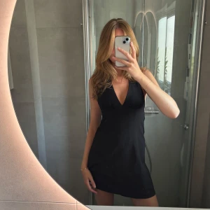 Svart halterneckklänning - Svart kort halterneckklänning från HM. Man knyter själv runt nacken så att man kan justera den som man vill ha den. Storlek 38 men passar också 36🥰✨