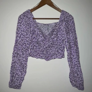 Lila blommig croppad blus - Superfin lila blus med blommigt mönster och croppad passform. Oanvänd