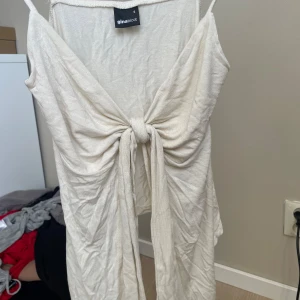 Vit omlotttopp från Gina Tricot - Supersöt beige tröja från Gina Tricot i mjuk bomull.Tröjan har omlott-design med knyt framtill och tunna axelband. Perfekt för sommarens alla tillfällen och ger en fräsch och trendig look. Passar dig som gillar stilrena och enkla plagg med en twist.