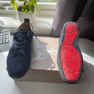 Christian Louboutin skor mörkblå - Snygga mörkblå sneakers från Christian Louboutin i mocka med klassisk röd sula. Perfekta för dig som vill sticka ut med exklusiv stil och vill ha ett par snygga skor som passar till allt, storleken är 41 men passar 42, skorna är i bra skick men det finns tecken på användning, tveka inte med att höra av dig vid minsta lilla fråga😁pris: 1200, det går att diskutera