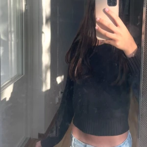 Svart stickad tröja - Svart croppad stickad tröja med lång ärm och ribbade muddar. Köpt på H&M i storlek XS