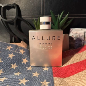 Chanel Allure Homme Édition Blanche 150ml - Chanel Allure Homme Édition Blanche är en lyxig herrparfym i en stilren, matt ljusguldfärgad flaska med svart text och vit kork med silverdetalj. Flaskan rymmer 150 ml eau de toilette och har en modern, fyrkantig design som känns både exklusiv och tidlös. Har ej kommit till användning, utan den bara tog plats. Nästan helt full, men kommer inte med förpackning.