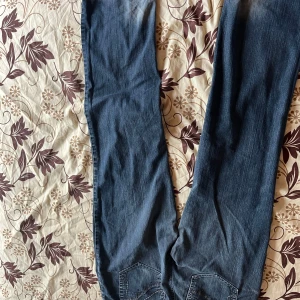Blå jeans med broderade bakfickor - Snygga blå jeans med raka ben och broderade detaljer på bakfickorna. Klassisk femficksmodell med dragkedja och knapp framtill. Jeansen har en lätt tvättad look och är tillverkade i mjukt denimtyg. Blue jeans. They are a M/L and very pretty on. Gives the pretty style without trying. Goes with a lot of things. Used 3-5 times.  