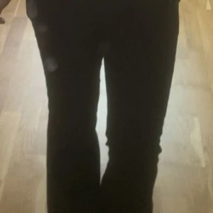 Svarta bootcut byxor - Säljer ett par svarta byxor med bootcut-modell. De har en klassisk passform med utsvängda ben och sitter snyggt i midjan. Perfekta för dig som gillar en stilren look med lite edge. 180kr utan frakt