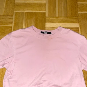 Ljusrosa t-shirt från Bik Bok - Säljer en ljusrosa t-shirt från Bik Bok i storlek XS. T-shirten har klassisk rund hals och korta ärmar,