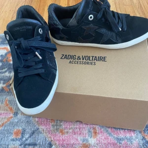 Zadig skor - Svarta sneakers från Zadig. Ena skon är ganska sliten vid hälen, inget som är för märkbart och märks absolut inte när man går i dem. Möts gärna upp 