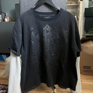 Seams t-shirt med coolt tryck - Cool svart t-shirt med inbyggda vita ärmar från Seams. Endast använd enstaka gånger. 