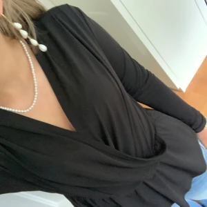 Svart omlottopp med lång ärm - Snygg svart omlottopp med lång ärm och v-ringad hals. Materialet är jätte skönt. Den är knappt använd!