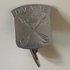 Silvriga manschettknappar Dalarne - Unika silvriga manschettknappar i rostfritt stål från Sandviken med Dalarne-emblem. Sköldformad framsida med ingraverad krona och korsade pilar. Perfekt för dig som vill ha en cool och personlig detalj till skjortan.