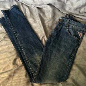 Replay jeans modell: Jondrill strl 30/32 - Säljer ett par replay jeans i blå tvätt med snyggt slitna detaljer. Modellen är slim fit med normal midja och raka ben. Jeansen har fem fickor, replay logga på fickan och är tillverkade i mjukt bomullsjeans. Perfekta för en avslappnad stil. Strl 30/32 jätte fint skick 