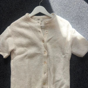 Beige stickad kofta med kort ärm - Superfin beige stickad kofta från Gina tricot strl xs och i bra sick knappt använd (slutsåld på butiker)