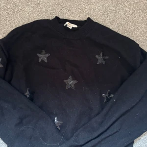 Svart stickad tröja med stjärnor Gina Tricot - Svart stickad tröja från Gina Tricot med snygga svarta paljettstjärnor framtill. Tröjan har rund halsringning och långa armar. Pris kan diskuteras ❤️