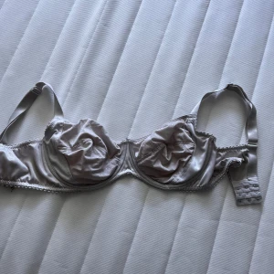 Beige BH med prickar - Snygg BJ i beige-silvrig satin från esmara med tunna axelband och bygel. Kuporna har ett diskret prickigt mönster och lätt rynkade detaljer. BH:n har inget vadd och är mycket bekväm. Storleken står inte men jag är väldigt säker på att den är 85C. Vid frågor hör av dig!