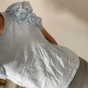 Ljusblå topp med volangärmar  - Supersöt ljusblå topp från Lindex med broderade volangärmar i bomull. I storlek 146/152 men skulle säga att den passar som xxs. Aldrig använd💕