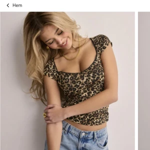 Leopardmönstrad topp - Snygg croppad topp med leopardmönster i bruna och svarta toner. Toppen har korta ärmar, rundad urringning med svart spetskant och figurnära passform. Helt oanvänd