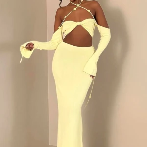 Ljusgul långklänning med snörning  - Trendig ljusgul långklänning med offshoulder och långa ärmar. Klänningen har snygg snörning över axlarna, twistad detalj vid bysten och slimmad passform. Perfekt för dig som vill sticka ut med en unik och modern look i sommar.    HAR GJORT OM TOPPEN SÅ DEN INTE ÄR SÅ ÖPPEN!