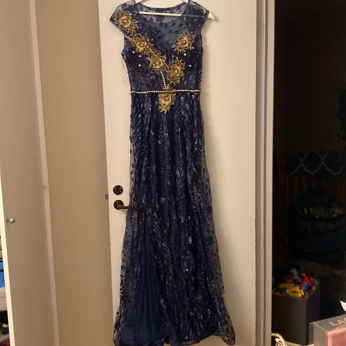 Marinblå långklänning med guldiga detaljer