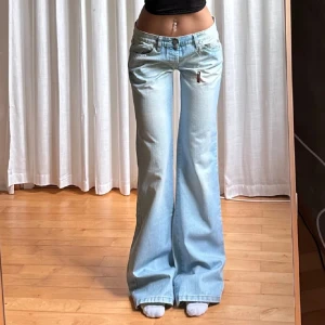 Ljusblå bootcut jeans - Säljer ett par ljusblå bootcut jeans med låg midja. Obs lånade bilder💕 från OTL, midja 41, innerbenslängd 87. Hon på bilden är 165. Aldrig använda🩷💕 jag köpte dessa för 900, skicka gärna prisförslag🙏🩷på lappen står det L men jag tycker att de passar som S 