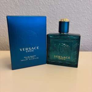 Versace Eros Eau de Toilette 100 ml - Versace Eros Eau de Toilette för herr i en lyxig turkosblå glasflaska med gulddetaljer. Flaskan rymmer 100 ml och har en elegant Medusa-logga på framsidan. Kommer i matchande blå kartong med guldtext.