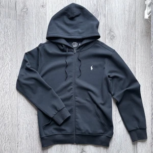Polo Ralph Lauren Zip Hoodie - Navy - Marinblå huvtröja med dragkedja från Polo Ralph Lauren. Storlek L. Nytt skick, inte använd. Tveka inte, hör av er vid funderingar! 😄