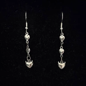 Silverfärgade örhängen med hjärtan - Handgjorda och unika silverörhängen 🤩 Öronhängerna är nickelfria och silverpläterade i kirurgiskt stål, resterande av örhänget är i rostfritt stål (ej silverpläterat) 💕🙏 4 cm långa. Alla köp görs via ”KÖP NU” knappen.  💐