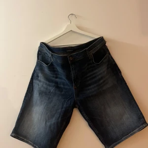 Mörkblå jeansshorts från Lindbergh - Säljer ett par mörkblå jeansshorts från Lindbergh. Klassisk femficksmodell med knapp och dragkedja i gylfen. Perfekta för varma dagar.