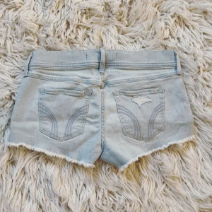 HOLLISTER ljusblåa Low rise jeanshorts  - Världens skönaste och snyggaste stretchiga jeanshorts med små söta pärlor ifrån hollister med lapp kvar! Aldrig anvönda av mig! Midja rakt över: ca 39 cm💞💞