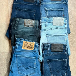 Mix av Replay jeans i olika blå nyanser - Säljer flera par Replay jeans i olika blå tvättar, från ljusblå till mörkblå. Klassisk femficksmodell med detaljerade bakfickor och läderpatch bak. Perfekta för dig som gillar jeans med snygg passform och stilrena detaljer.
