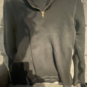Svart halvzip tröja - Svart tröja med halv dragkedja i halsen. Klassisk och enkel design. Riktigt skön att ha på sig. Inga fläckar eller defekter. Passar dig som är mellan 150-165 