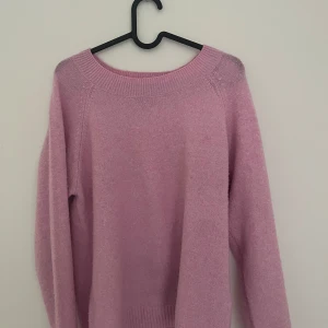 Ljusrosa stickad tröja från Vero Moda - Superfin ljusrosa stickad tröja från Vero Moda. Tröjan har rund halsringning, långa ärmar och ribbade muddar vid ärmslut och nederkant. Perfekt sommar färg !