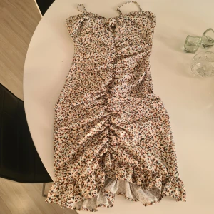 Svart klänning med paljettkjol från Vila - Säljer en svart klänning från Vila med mjuk, glansig topp och en kjol täckt av svarta paljetter. Klänningen har korta ärmar och markerad midja, perfekt för dig som vill sticka ut.