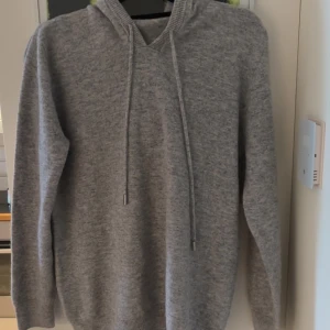 Grå kashmir hoodie - Kashmir tröja som inte har ett märke och som är helt ny, säljs för 600 kr priset diskuteras inte. Den är i storlek M/L