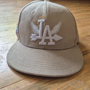 Beige keps med LA-brodyr och palm-motiv - Snygg beige keps från La den är väldigt skön. Pris kan sänkas