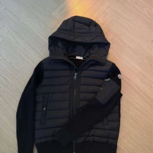 Svart Moncler Cardigan - Säljer min brors svarta moncler cardigan. Säljer den eftersom den inte passade honom. Den är använd 2-3 gånger, jättefint skick, som ny💕 PRIS KAN DISKUTERAS!!🫶🫶