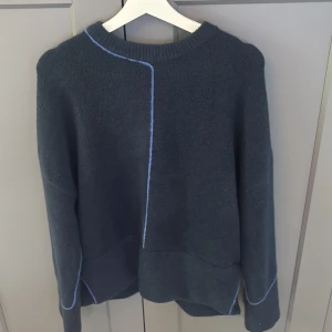 mörkblå tröja med blå sömmar från Zara - Säljer en blå tröja från Zara i storlek M. Tröjan har unika blå kontrastsömmar som detalj och en avslappnad passform. Perfekt för dig som gillar stilrena plagg med en twist.