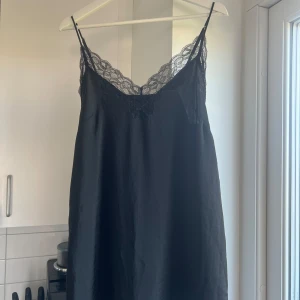 Svart spetsklänning från H&M - Säljer en svart klänning från H&M med tunna axelband och vacker spetsdetalj upptill. Den är nog tänkt som ett nattlinne men funkar super bra som klänning också. Klänningen har en slät och enkel design. Storlek m🌸