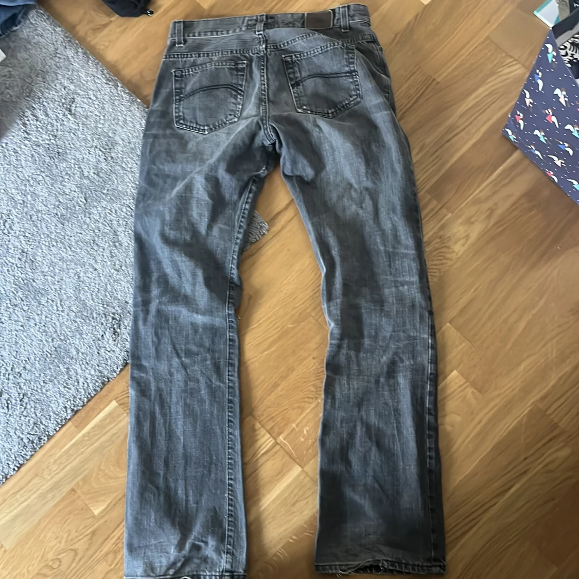 Grå jeansbyxor med slitning