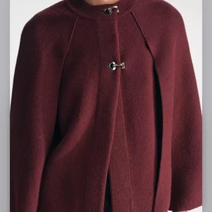 Vinröd kappa  - Säljer denna stickade jacka fast i en MÖRKGRÅ färg, den är oanvänd med prislapp kvar. Nypris 699 