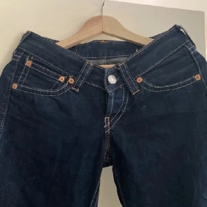Levis jeans med bootcut - Snygga mörkblå Levis jeans med bootcut och klassisk femficksdesign. De har en lågmidjad passform och är tillverkade i slitstarkt denim. storlek 36 eller 38 tror jag kom privat för måtten