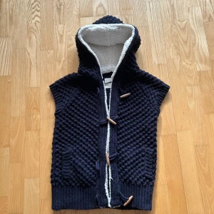 Mörkblå stickad väst från Zaraknit - Säljer en mörkblå stickad väst från Zaraknit med huva. Inga synliga defekter