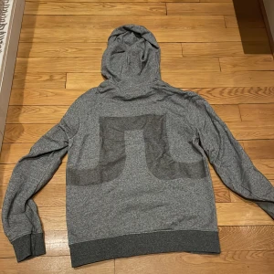 Grå hoodie från J.Lindeberg - Säljer en stilren grå hoodie från J.Lindeberg. Perfekt för en avslappnad look.