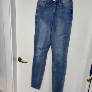 Blå jeans från Sinner - Snygga blå jeans från Missguided med hög midja och skinny fit. De har slitna detaljer på framsidan som ger en trendig look. Perfekta för en avslappnad stil.