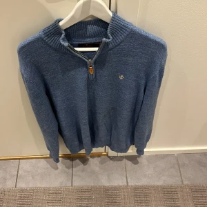 Blå stickad tröja från Morris - Säljer en snygg blå stickad tröja från Morris med dragkedja vid halsen. Tröjan har långa ärmar och en liten broderad logga på bröstet. Är storlek L men sitter mer som M. Pris kan diskuteras. 