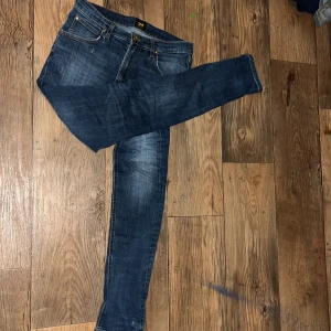 Blå jeans från Lee - Snygga blå jeans från Lee med klassisk femficksdesign och dragkedja. De har en straight passform och är perfekta för en avslappnad stil. Märkeslogga på baksidan ger en extra touch. Skriv mer i privat!