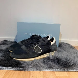 Philippe Model trainers - Ett par mörkblåa sneakers från Philippe Model med vita detaljer som passar till de mesta. Skorna är riktigt fräscha nu till sommaren och väldigt sköna! Hör av dig vid fler frågor!