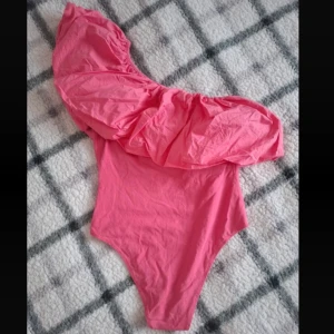 Rosa body med volang - Snygg rosa baddräkt med en axel och volangdetalj💘
