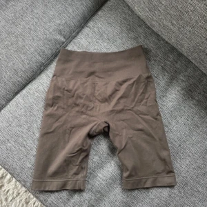 Bruna shorts från Relode - scrunch - Säljer ett par bruna shorts från Relode. De är högmidjade och har en tight passform, perfekta för träning. Shortsen har en elastisk midja och är tillverkade i ett mjukt och stretchigt material för bästa komfort.
