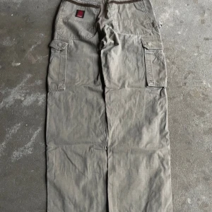 Vintage khaki baggy cargo byxor - Skick: 8,5/10 storlek: 28.                 Midja: 37,5 cm. Längd: 101 cm. Ben öppning: 24 cm. Hör gärna av er vid frågor!